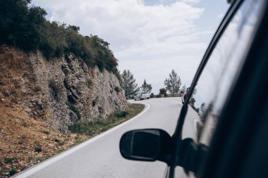 Hareket veya bir yol macera ya da bir gezi. Arka yolcu koltuktan asfalt dağ yolu ve hareketli araba öncesinde görüntüleyin. Yaşam tarzı