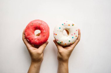 Kız çörek ellerinin beyaz bir arka plan üzerinde tutuyor