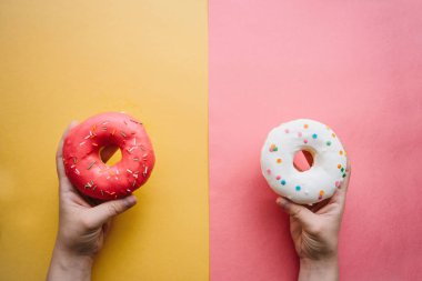 Kız iki donut ellerinde tutuyor