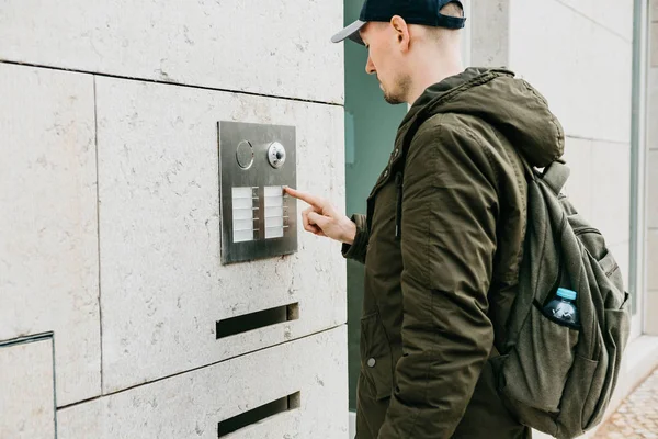 Un résident local masculin ou un touriste clique sur le bouton de la porte ou appelle l'interphone. Arrivée et appel de rue en chambre — Photo