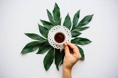 Kız güzel kokulu lezzetli bitkisel bir bardak alır veya siyah çay içip rahatlayın gidiyor