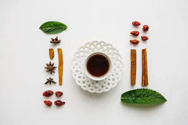 Datar berbaring secangkir wangi dan lezat herbal atau teh hitam di permukaan putih dan berbagai bahan — Stok Foto