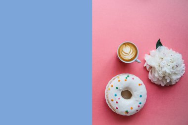 Cappuccino kahve ve çörek renkli yüzeyi. Beyaz bir çiçek