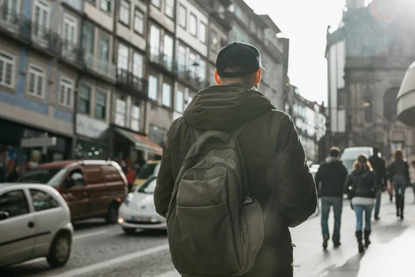 A tourist with a backpack walks down the street in Porto in Portugal. Travel around Portugal — Stock Photo, Image