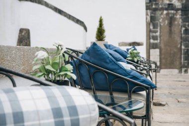 Yastıkları bir cadde terası veya sokak bir kafe ile rahat banklar.