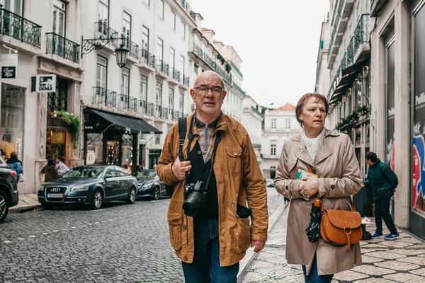 An elderly couple of European tourists are walking around Lisbon in Portugal. — Stock Photo, Image