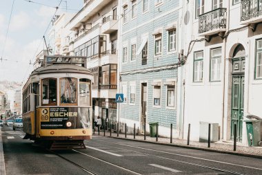 Geleneksel sarı eski moda veya retro tarzı tramvayla şehir Lizbon Portekiz sokak aşağı.