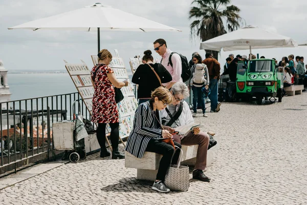Mature couple sitting on a bench and looking at a map in Lisbon in Portugal. — Stock Photo, Image
