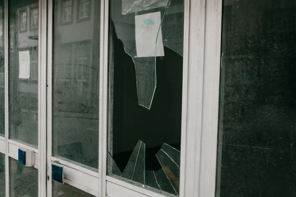 Разбитое окно в результате землетрясения, вандализма или другого негативного события . — стоковое фото
