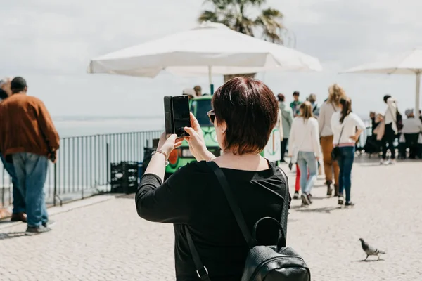 Una turista hace una foto en un celular en memoria en la plataforma de observación de Lisboa en Portugal . — Foto de Stock