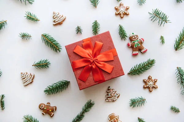Kerstmis of Nieuwjaar cadeau in een rood vak. In de buurt zijn dat diverse Vakantiewoningen dingen met inbegrip van gember koekjes. — Stockfoto