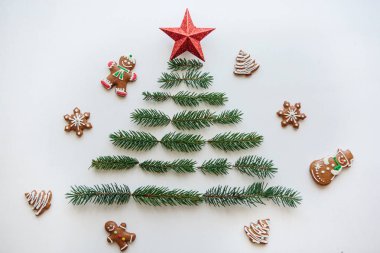 Bir Noel ağacı çam dalları ve üst bir yıldız. Yakınlarda gingerbread çerezleri yalan.