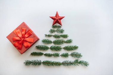 Noel ve yeni yıl tema için yaratıcı bir fikir. Yaratıcı bir Noel ve yeni yıl ağacı köknar şube ve üst bir yıldız yaptı. Yanında kırmızı bir kutu için bir hediye.