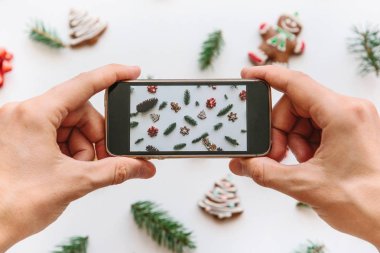 Bir adam bir Noel ve yeni yıl arka plan cep telefonundan fotoğraf çekimi.