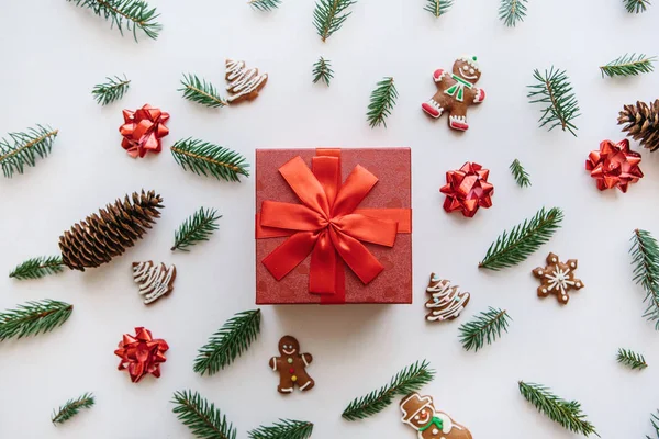 Kerstmis of Nieuwjaar cadeau in een rood vak. In de buurt zijn dat diverse Vakantiewoningen dingen met inbegrip van gember koekjes. — Stockfoto
