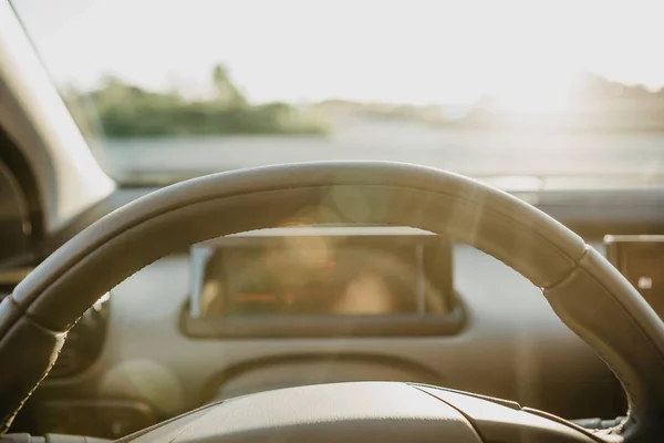 Volante e vista através de vidro no fundo por do sol . — Fotografia de Stock