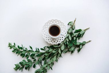 Bir fincan taze aromalı espresso ya da siyah çay bitki dalları yanındaki.