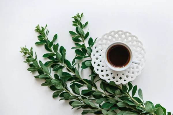 Bir fincan taze aromalı espresso ya da siyah çay bitki dalları yanındaki.