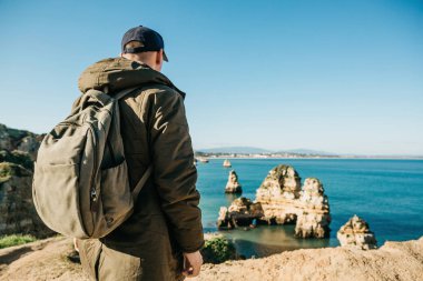 Turist veya gezgin Atlantik kıyısında bir sırt çantası ile.