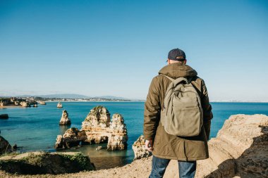 Turist veya gezgin Atlantik kıyısında bir sırt çantası ile.