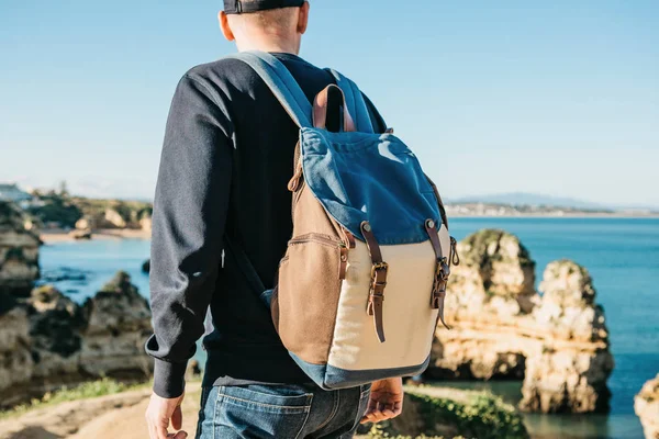 Turist veya gezgin Atlantik kıyısında bir sırt çantası ile.
