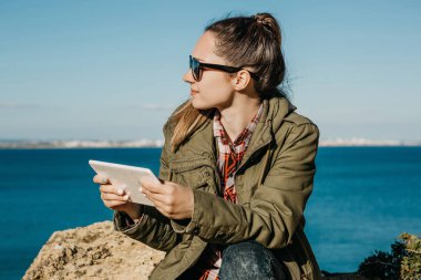 Genç güzel kız ya da turistik bir tablet kullanır.