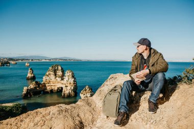 Genç bir adam bir tablet kullanır ve mesafe içine görünüyor.