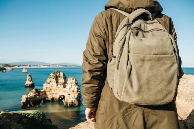 Turist veya gezgin Atlantik kıyısında bir sırt çantası ile.