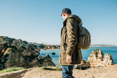 Turist veya gezgin Atlantik kıyısında bir sırt çantası ile.