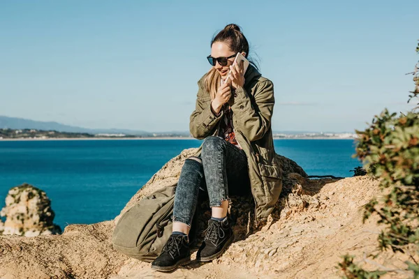 Mujer joven o turista utiliza una tableta o teléfono móvil para hablar . — Foto de Stock