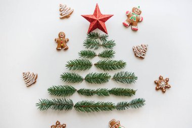 Bir Noel ağacı çam dalları ve üst bir yıldız. Yakınlarda gingerbread çerezleri yalan.