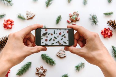 Bir adam bir Noel ve yeni yıl arka plan cep telefonundan fotoğraf çekimi.