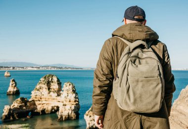Turist veya gezgin Atlantik kıyısında bir sırt çantası ile.
