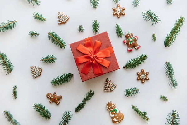 Kerstmis of Nieuwjaar cadeau in een rood vak. In de buurt zijn dat diverse Vakantiewoningen dingen met inbegrip van gember koekjes. — Stockfoto