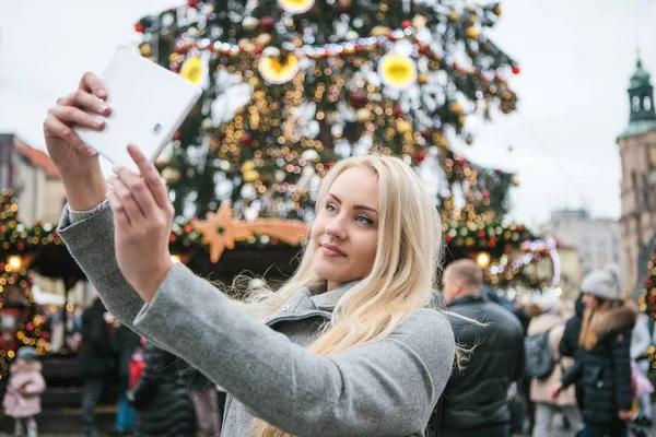 Een mooie jonge blonde vrouw of meisje doet selfie of fotograferen. — Stockfoto