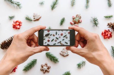 Bir adam bir Noel ve yeni yıl arka plan cep telefonundan fotoğraf çekimi.