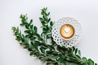 Taze kokulu kapuçino bitki dalları yanında kahve bir fincan.