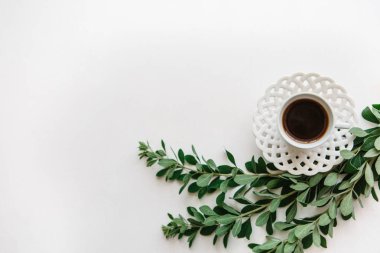 Bir fincan taze aromalı espresso ya da siyah çay bitki dalları yanındaki.