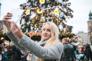 Güzel sarışın genç kadın veya kız selfie yapıyor veya fotoğraf çekimi.