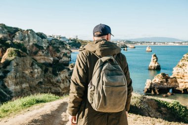 Turist veya gezgin Atlantik kıyısında bir sırt çantası ile.