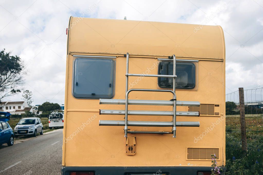 A motor home or a house on wheels is parked on the side of the road.