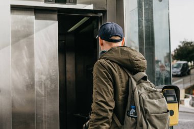 Metro ile gitmek Porto Portekiz sokak asansörde bir sırt çantası ile bir turist adam kullanır