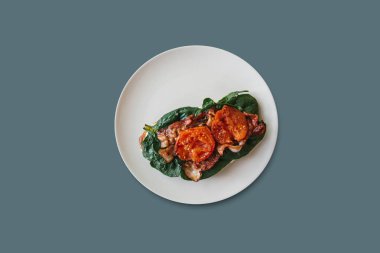 Lezzetli ve besleyici tost ya da sandviç sosis, ıspanak ve domates üzerinde gri bir arka plan ile. Lezzetli yemekler