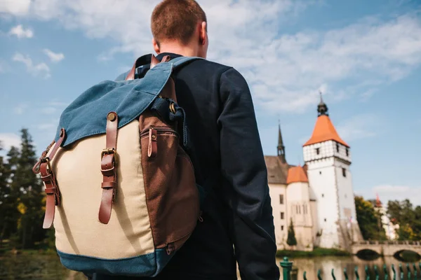 Турист с рюкзаком смотрит на достопримечательности. Замок Блатна в Чешской Республике размыт на заднем плане. Отдых, путешествия . — стоковое фото