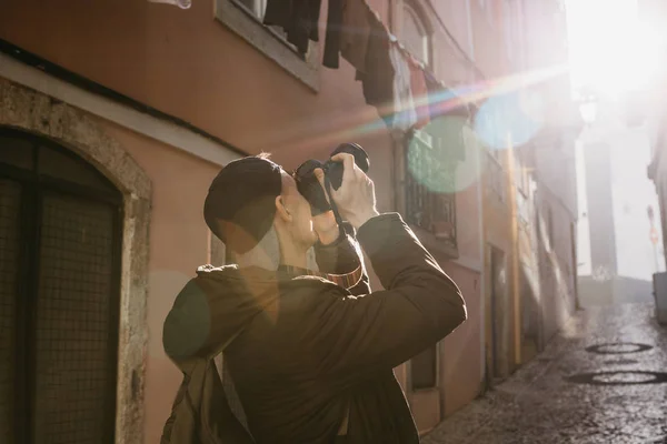Utcai fotós, vagy egy fiatal ember veszi a képek a hiteles házak, Lisszabon, Portugália. Egy profi fotós, vagy a turisztikai bevétel mozi-memória — Stock Fotó