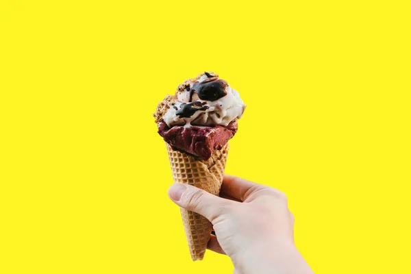 The girl is holding a delicious ice cream in her hand in a minimal style on a pink background. Summer concept