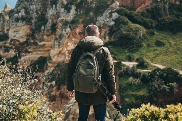 Bir fotoğrafçı ya da bir kameraman veya gezgin bir sırt çantası ve tripod elinde.