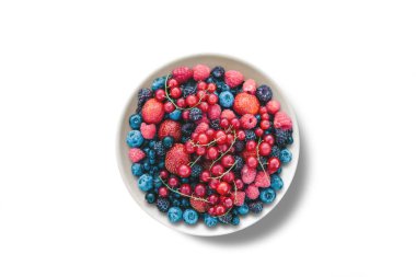 Beyaz bir arka plan üzerine bir tabak içinde çeşitli meyveler.