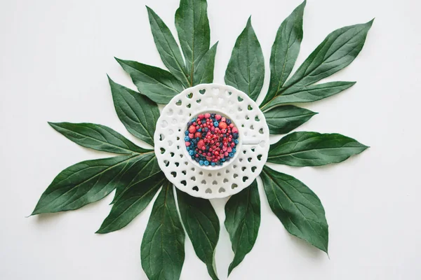 Çeşitli meyveler ile dolu bir kupa yeşil yapraklarda standları.