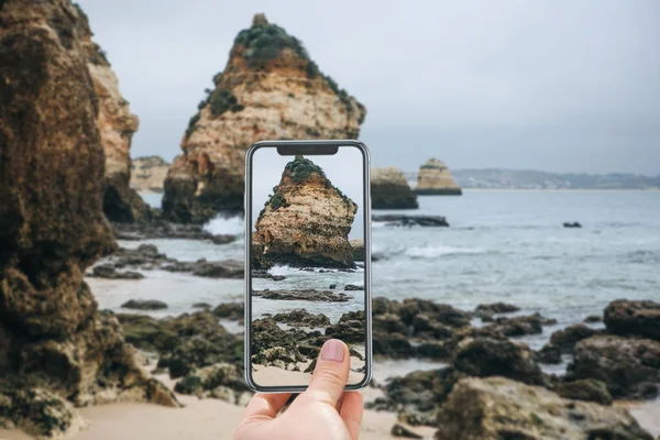 Un turista en la costa atlántica de Portugal toma fotos de las hermosas vistas del océano y las rocas . — Foto de Stock